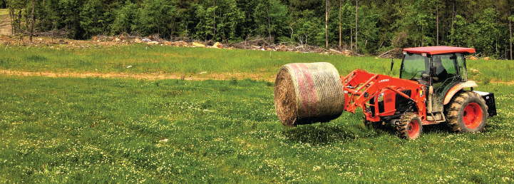 Tractor carrying hay through a field